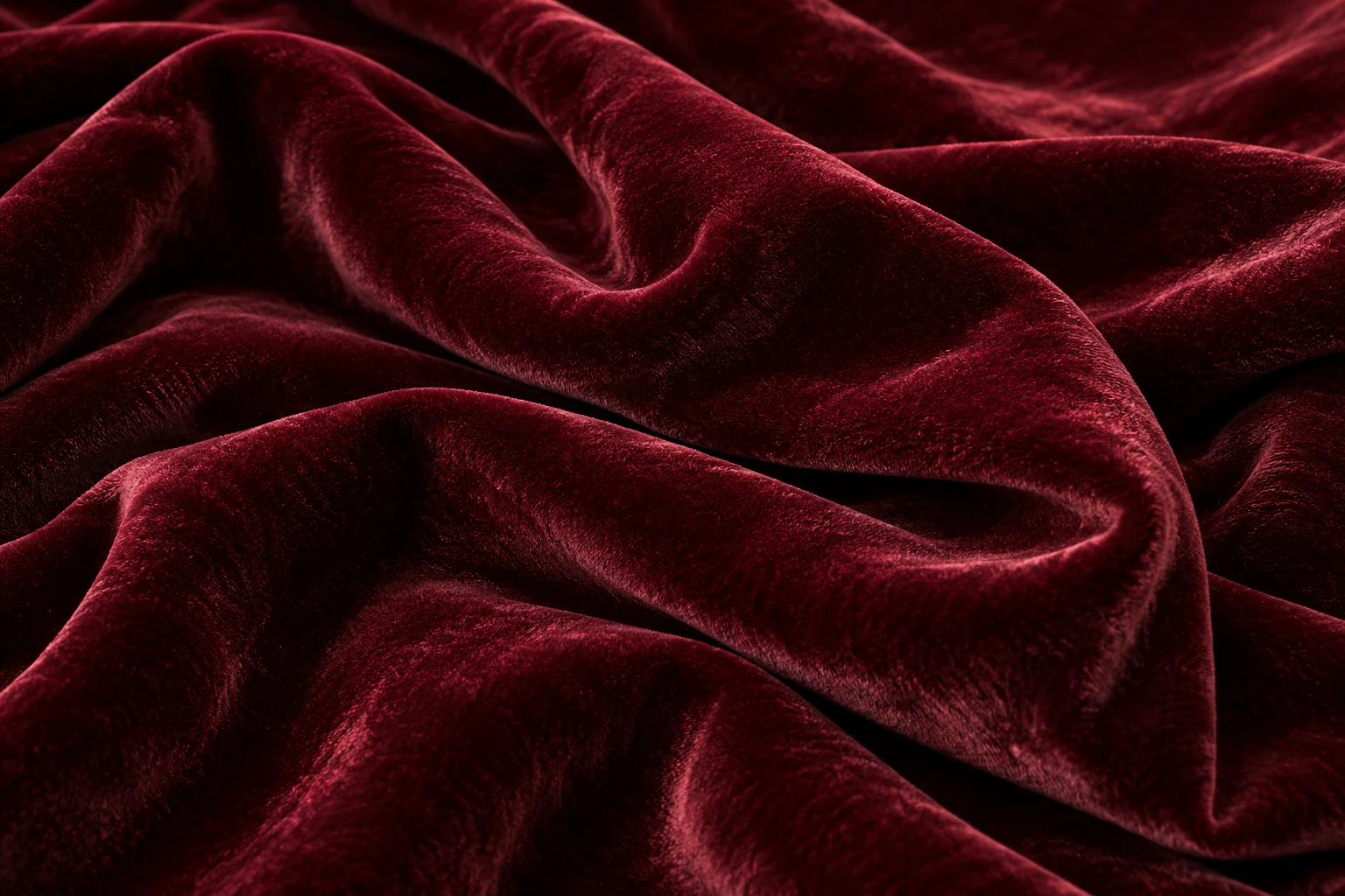 Illustrative deep oxblood velvet folds showing a soft pile and subtle sheen